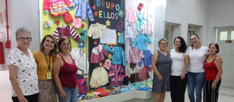 Peças de tricô produzidas pelas mulheres voluntárias do Grupo ELLOS são expostas em vitrine na IENH